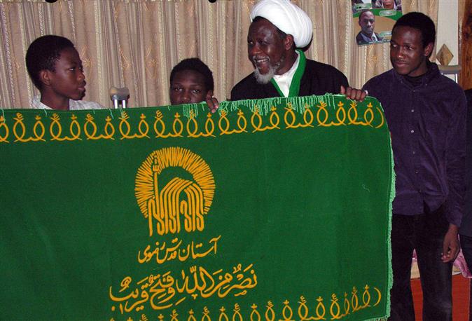 إهداء رایة حرم الإمام الرضا(ع) للشیخ الزکزاکی فی معتقله فی نیجیریا
